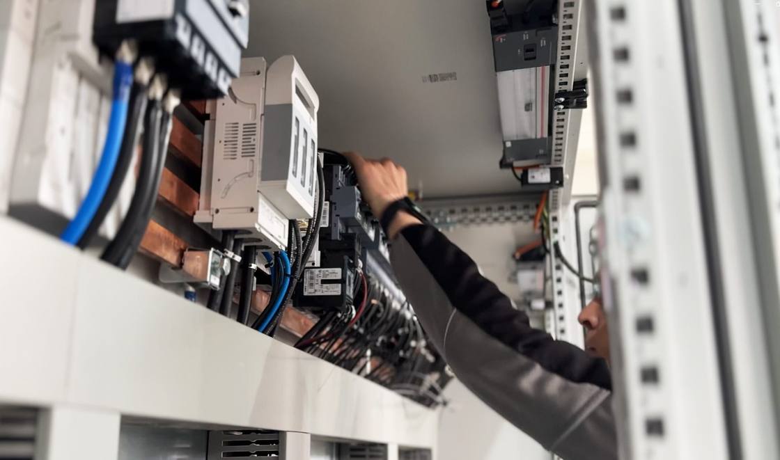 AGF technician wiring an electrical cabinet in the workshop