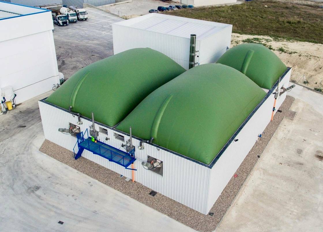 Columnas de proceso y contenedor AGF de una planta de biogás bajo cielo nublado