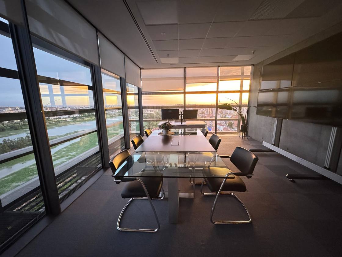 Sala de reuniões do gabinete de engenharia da AGF ao entardecer, com vista para a cidade e o rio